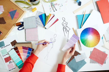 Hands of designer drawing sketch of new trendy clothingの写真素材