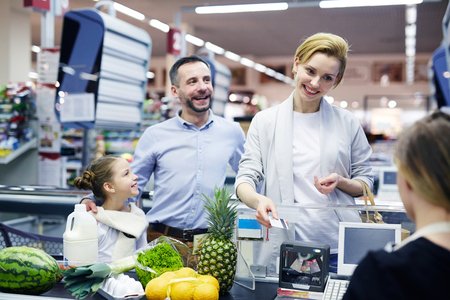 Family by supermarket checkoutの写真素材