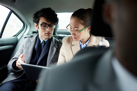 Business People Discussing Document in Carの写真素材