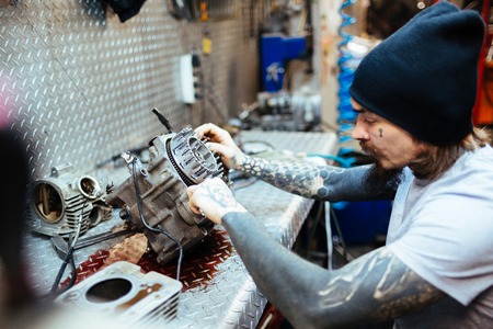 Tattooed Mechanic Assembling Engine Partsの写真素材