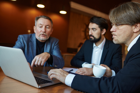 Business Meeting in Dim Coffeehouseの写真素材