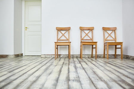 Row of wooden chairs along wall of roomの写真素材