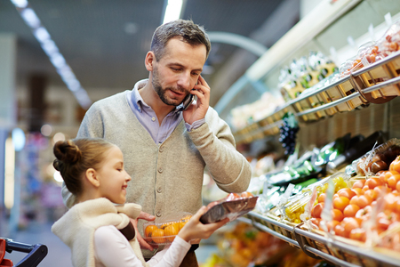 Man Calling Wife from Grocery Storeの写真素材