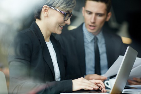 Smiling Businesswoman Using Laptop in Meetingの写真素材