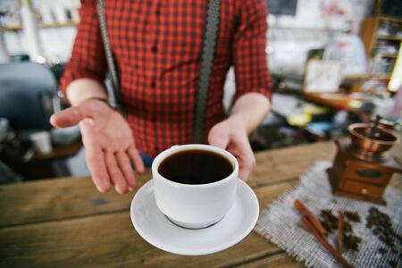 Trendy Barista Presenting Cup of Black Coffee in Barの写真素材