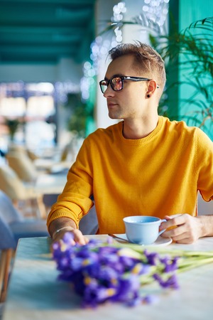 Romantic Guy Waiting for Date in Cafeの写真素材