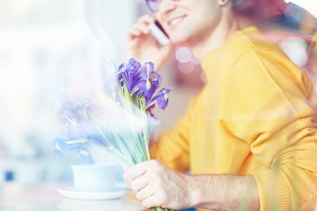 Smiling Man Calling Girlfriend in Cafeの写真素材