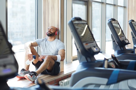 Sportsman Resting in Sunlight by Window in Gymの写真素材