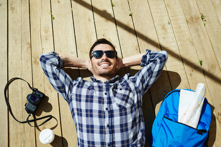 Young Traveler Resting in Sunlightの写真素材