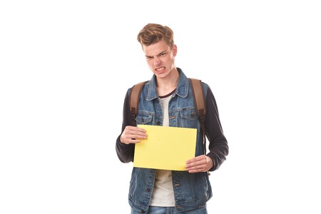 Portrait of schoolboy posing with blank paper against white backgroundの写真素材