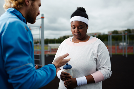 Weight-loss coach motivating plus-size African woman