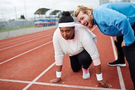 Personal trainer motivating overweight woman preparing for run competition