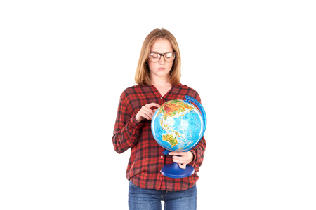 Studio portrait of female college student posing with globe isolated on white