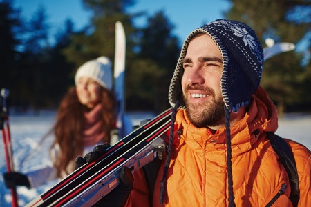 Young man and his wife with skiing equipment enjoying winter adventure during vacationの写真素材