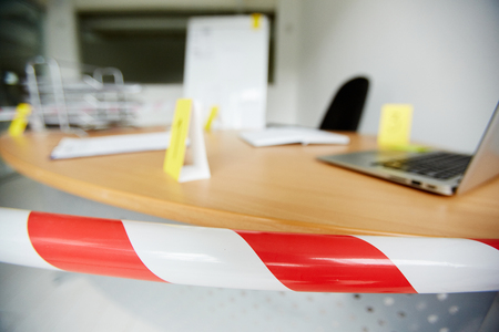 Crime scene in office bound by police tape to save fingerprints and other evidenceの写真素材