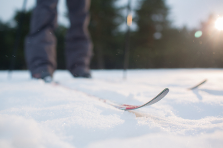Ski track and human on skis standing on white snow during training in parkの写真素材