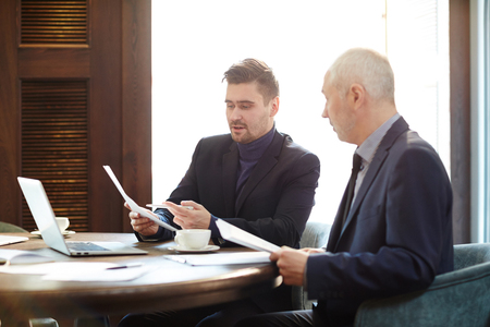 Two business coworkers having a meeting and discussing financial report togetherの写真素材