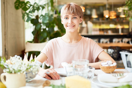 Attractive female sitting in cafe and smilingの写真素材