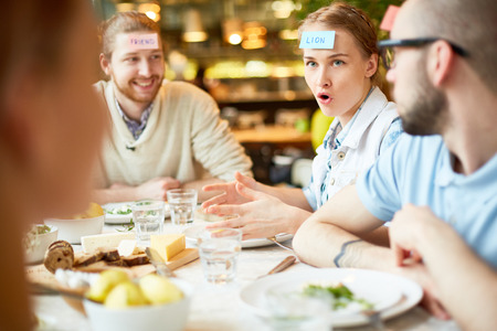 Group of friends gathering in cafe and playing gamesの写真素材