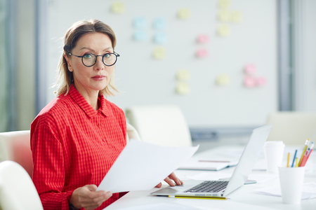 Serious woman at workplace in officeの写真素材