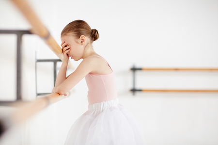 Young ballerina staying in studio with closed faceの写真素材