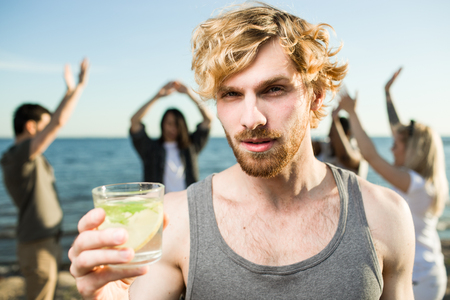 Young man with beverage on partyの写真素材