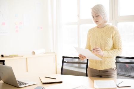 Woman reading document in officeの写真素材