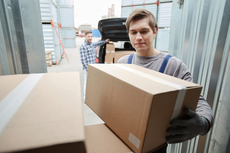 Smiling worker assisting client to loading carの写真素材