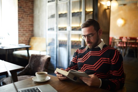 Man reading in cafeの写真素材