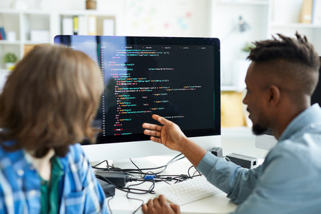 Busy colleagues analyzing computer code
