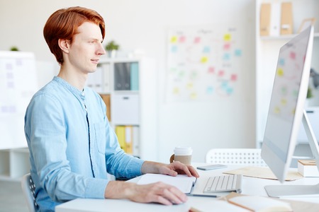 Redhead graphic designer working in office