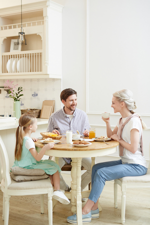 Talkative family enjoying breakfastの写真素材