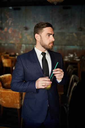Worried businessman drinking juiceの写真素材