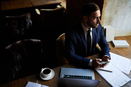 Thoughtful businessman reading messageの写真素材