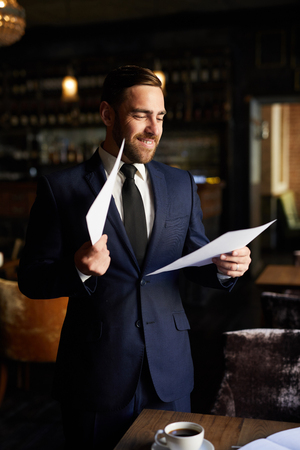 Excited businessman reading reportの写真素材