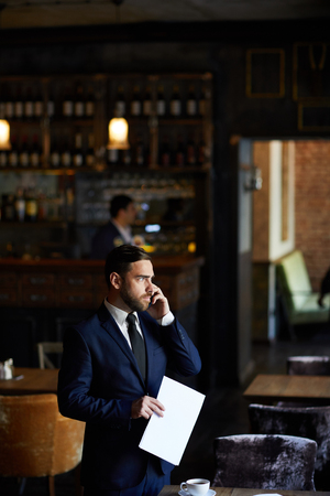 Restaurant manager talking on mobile phoneの写真素材