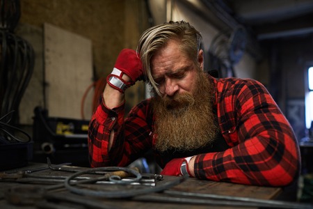 Tired craftsman sleeping at table after overworkingの写真素材