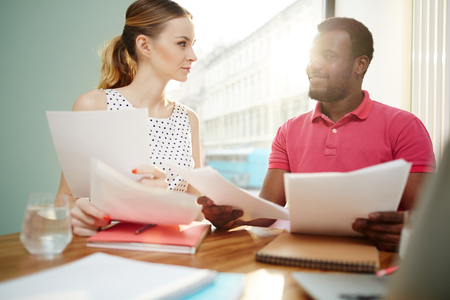 Businesspeople discussing papers in officeの写真素材