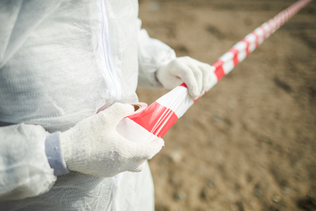 Crop volunteer pulling caution tapeの写真素材