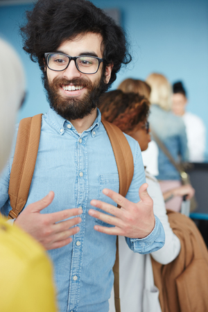 Smiling man talking in queueの写真素材