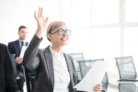 Cheerful woman having question on business meetingの写真素材