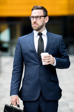 Man with plastic cup near office buildingの写真素材