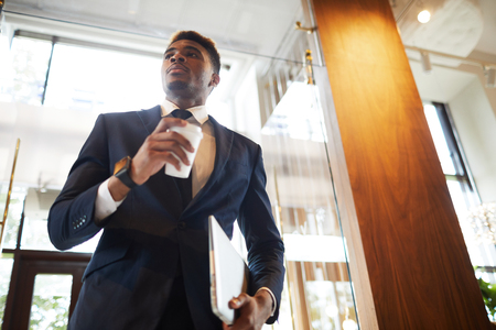 Modern businessman drinking coffee from disposable cupの写真素材