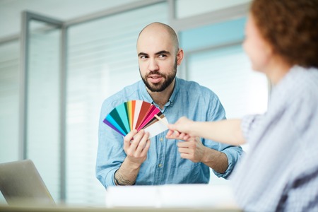 Bearded designer asking advice of colleague about color combinatの写真素材