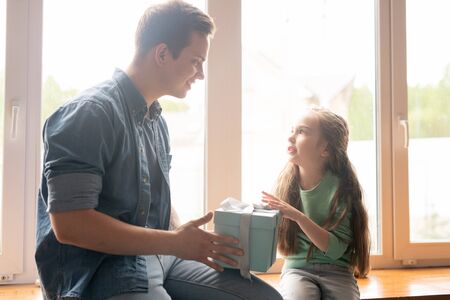 Pretty daughter giving gift to fatherの写真素材