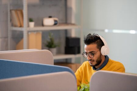 Arabian office worker in headphonesの写真素材