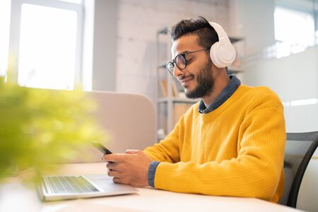 Young man enjoying work in office