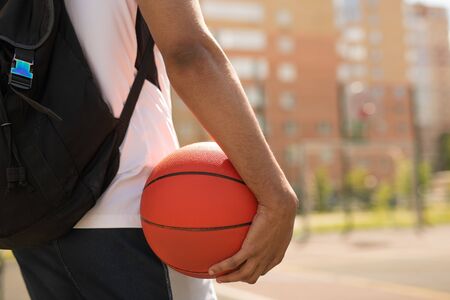Young basketball player with ball and backpackの写真素材