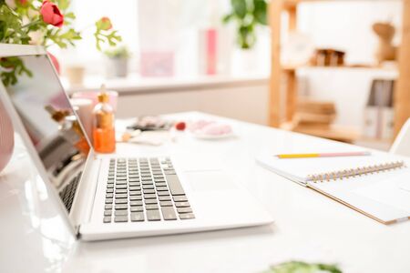 Open laptop and notebook on desk of contemporary interior designerの写真素材