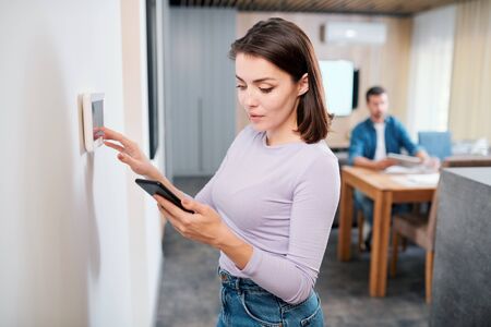 Young female installing new system of smart remote control in digital tablet